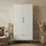 [White] Freestanding white wardrobe with drawer placed in softly lit room with neutral walls and minimal decor