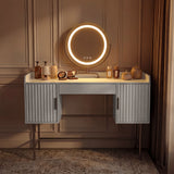 [White] white flutrina dressing table with warm amber-lit round LED mirror against panelled brown wall, no stool in shot