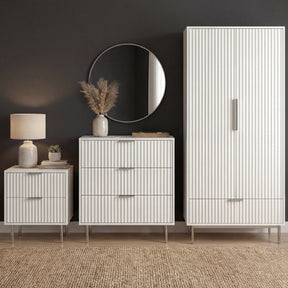 [White] flutrina white wardrobe, chest of 3 drawers and bedside table grouped on a woven rug under a round mirror