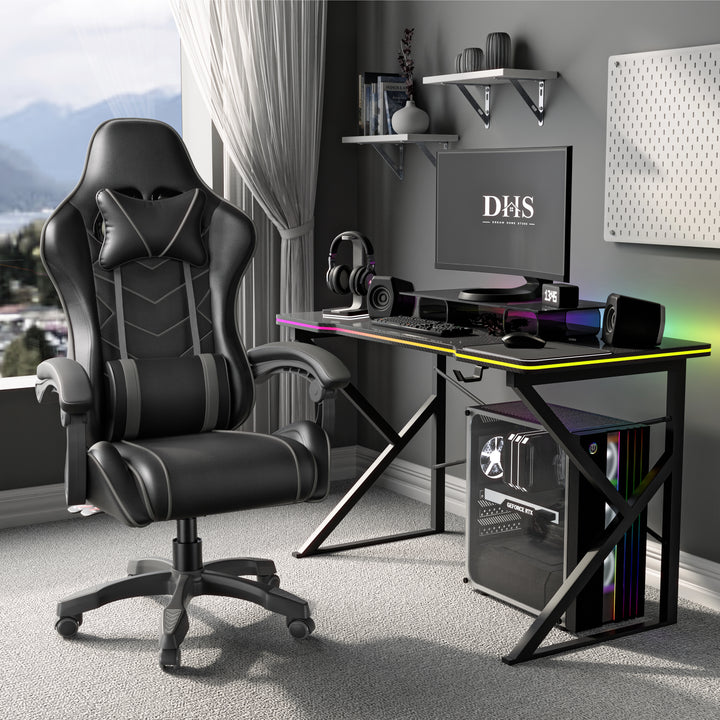 [Black + Grey] Gaming desk setup with a black and Grey  chair, monitor, and computer components in a room with large windows.