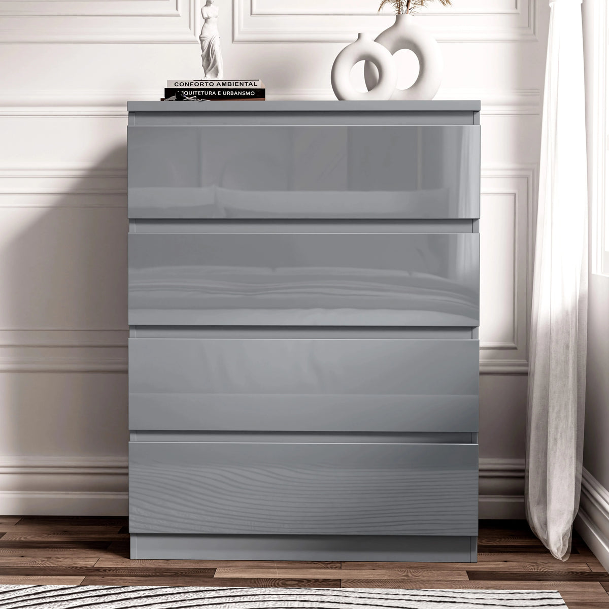 [Grey] Straight-on grey gloss 4 Drawer Chest of Drawers, vase and book stack styled on top against white panels.