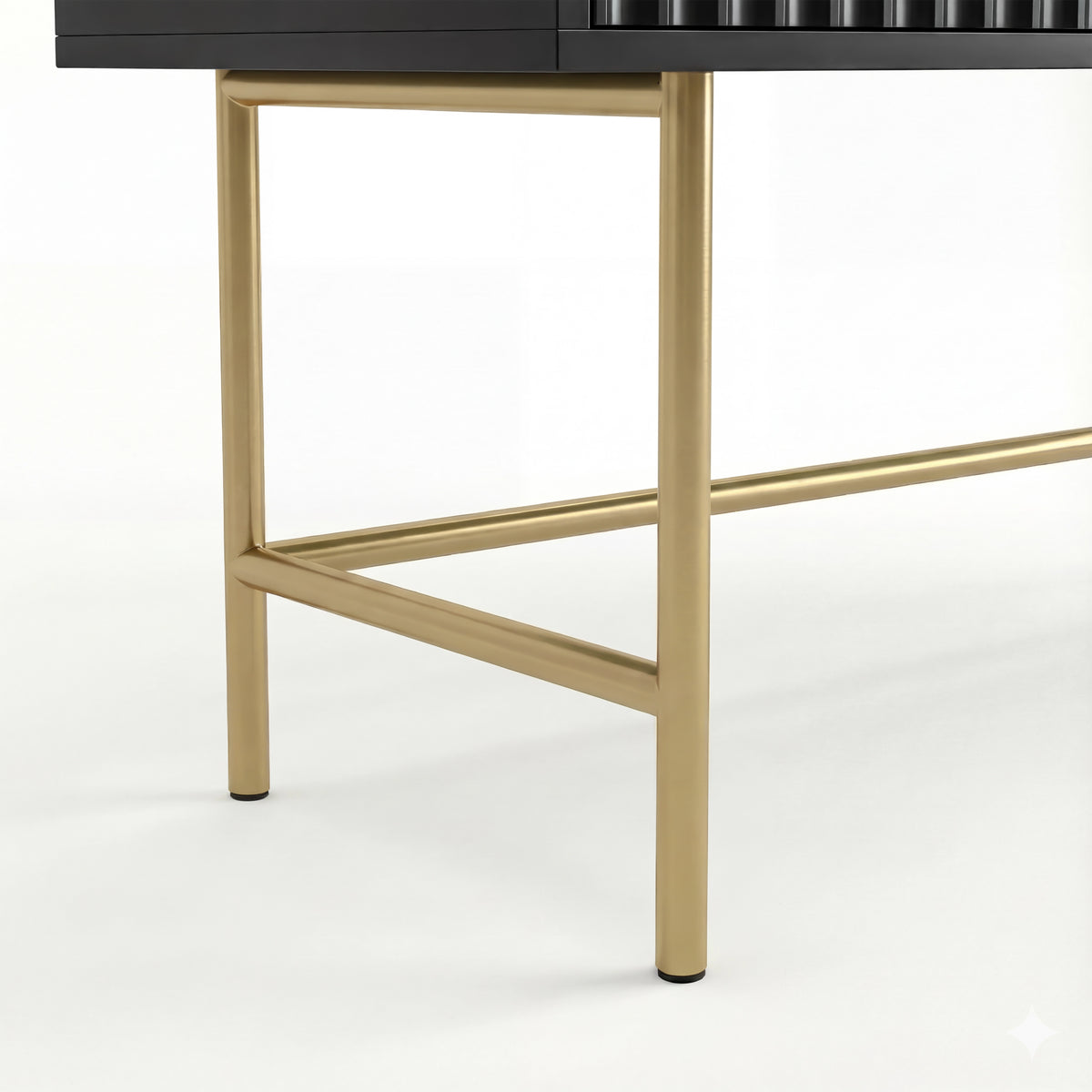 [Black] close-up of two gold square-tube legs and a low gold stretcher beneath the black flutrina dressing table