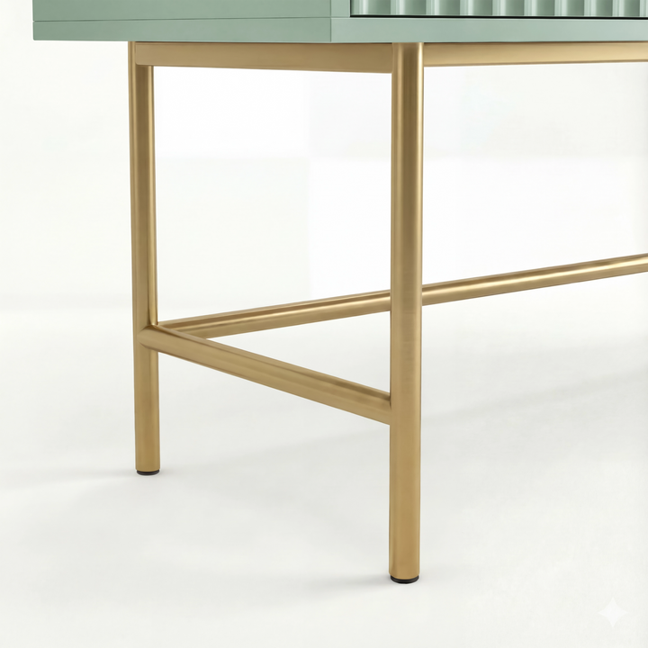 [Sage Green] close-up of two gold square-tube legs and a low gold stretcher beneath the sage green flutrina vanity