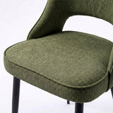 [Green | Set of 4] Comfy dining chair close-up of padded seat, piped edge, curved open back and black metal legs.