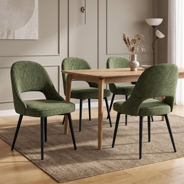 [Green | Set of 4] Four curved-back dining room chairs with piped seats and black legs arranged around a light wood table.