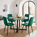 [Green] Velvet dining chairs around a round grey table, with curved tufted backs, armless seats and black legs.