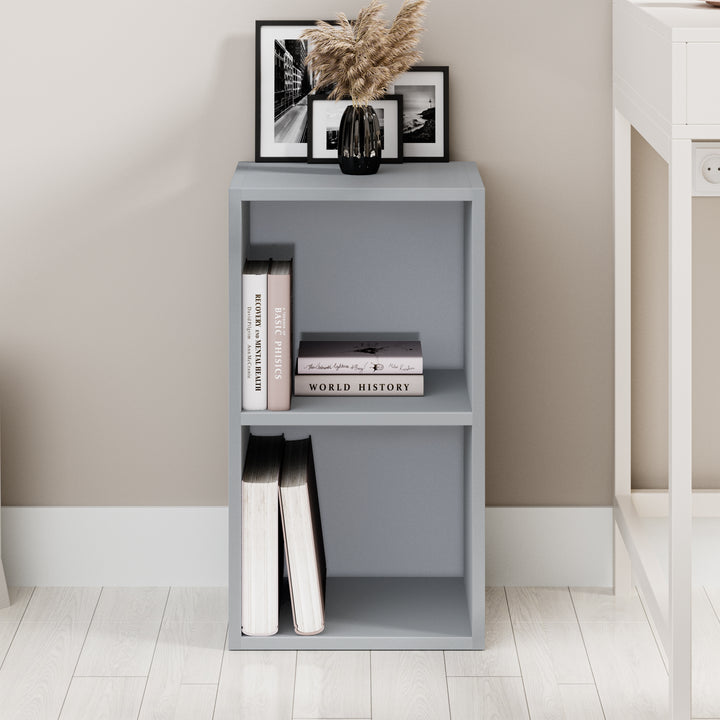 [2 Shelf | Grey] straight face of grey panel under-window short cube bookcase over pale concrete floor