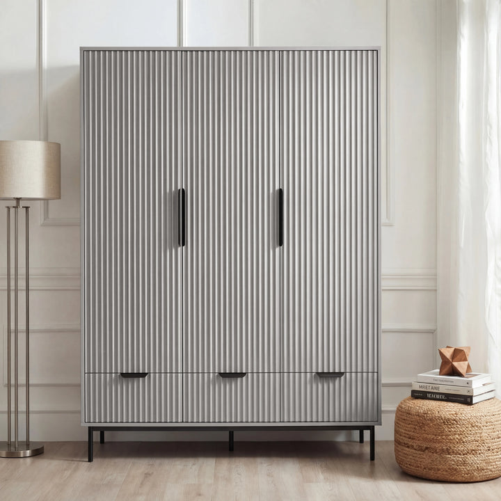 [Grey] flutrina design triple wardrobe with drawers and black handles placed against a wall in a bedroom