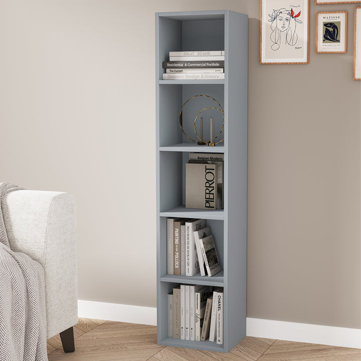 [5 Shelf | Grey] column-style grey-toned bookcase rising along chair by blue-grey painted wall