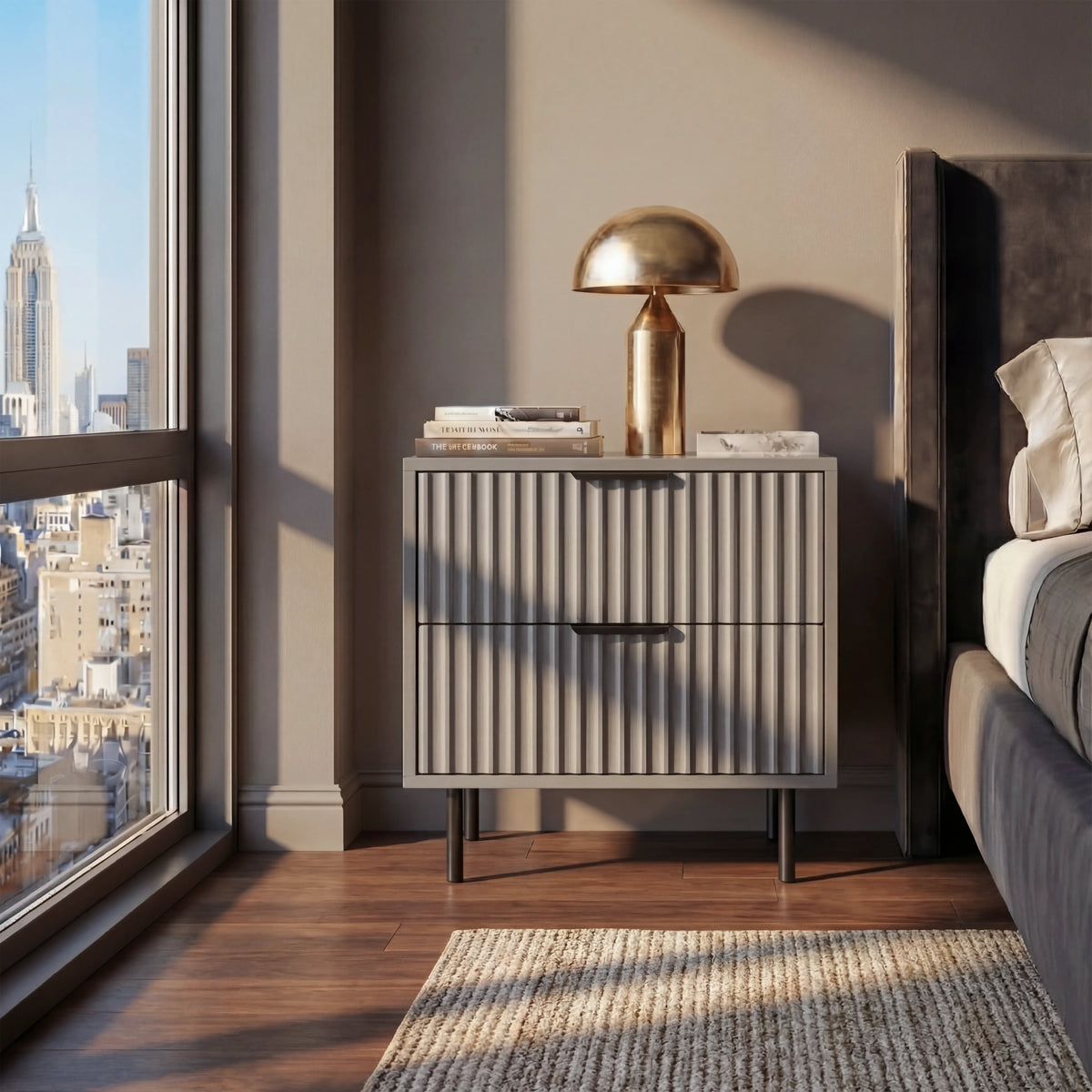 [Grey] bedside cabinet with drawer storage containing black handles and legs positioned beside a bed in a room