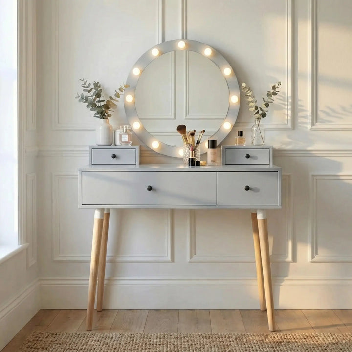 [Grey] Dressing Table With Drawers shown front-on with lit Hollywood mirror, eucalyptus stems, perfume bottles, and brushes in sunlit panelled space