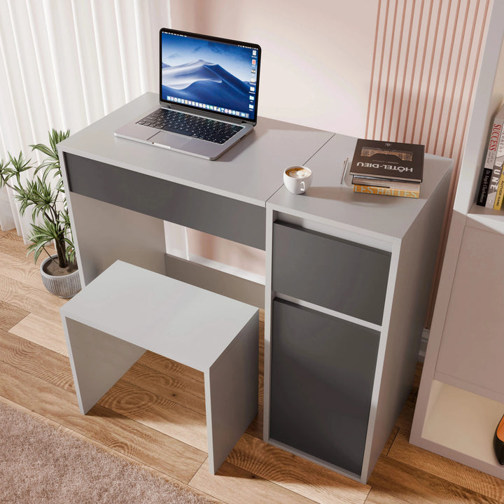 [Grey]  desk with a laptop, books, and a cup on a wooden floor.