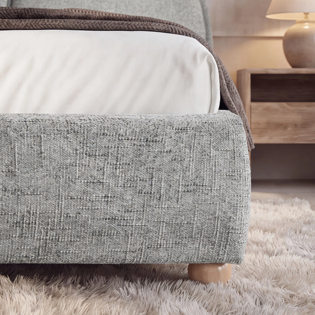 [Double | Grey] Embracea footboard detail showing boucle fabric texture and small natural rounded wooden feet
