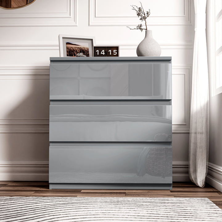 [Grey] front view of grey 3 drawer chest from the high gloss bedroom range, framed photo and clock displayed on top