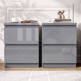 [Grey] Two modern nightstands with a glossy high-shine finish, shown side by side against a white paneled wall with decorative books and a coffee cup on top.