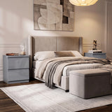 [Grey] A modern bedroom featuring a bed with a tall upholstered headboard, beige bedding, a matching ottoman in a neutral-toned room.