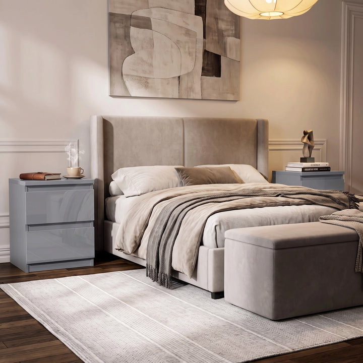 [Grey] A modern bedroom featuring a bed with a tall upholstered headboard, beige bedding, a matching ottoman in a neutral-toned room.