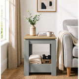 [Grey] Front view of the square side table beside a sofa, with a folded throw and basket stored below