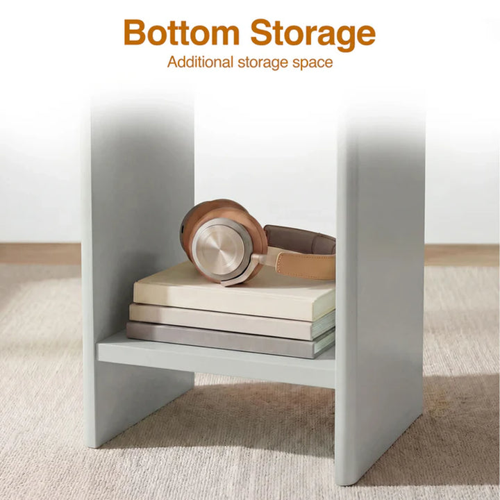 [Grey] Small Round Side Table with Shelf Living Room close-up of lower storage shelf between panel legs holding stacked books and headphones on beige rug