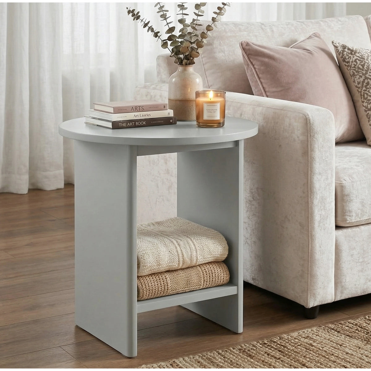 [Grey] Small Round Side Table with Shelf Living Room beside cream sofa with stacked books and lit candle on top and folded throws on lower shelf