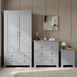 [Grey] Wardrobe, chest and bedside shown together against panelled wall with oak tops, decor, lamp, and rug