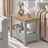 [Grey] Angled side table view showing a ring-shaped vase and glass candle on the top, with books on the lower shelf.