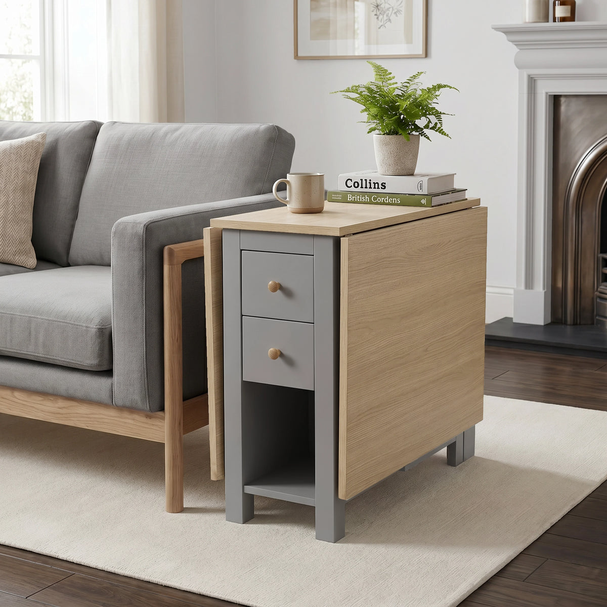 [130CM | Grey] Stovra Drop Leaf Dining Table used as a side table beside a sofa with one leaf extended and plant on top