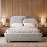[Double | Grey] Front view grey king ottoman bed frame centered between wooden nightstands with warm lamps and wall art