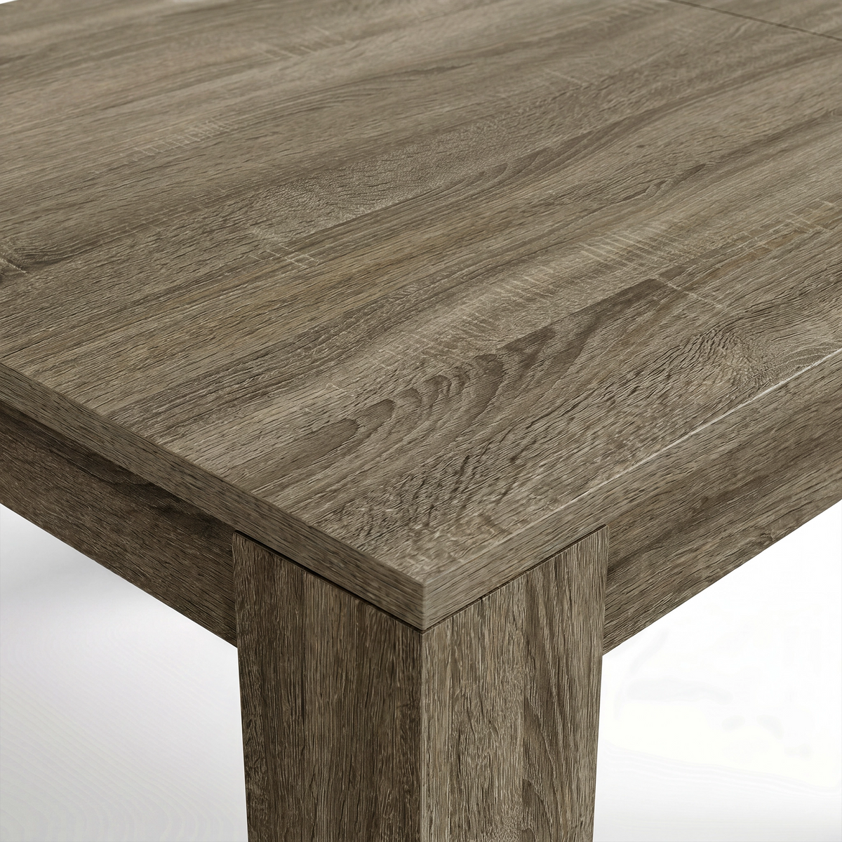 [Wooden Grey] Close-up of the grey wood-effect tabletop corner and thick L-shaped leg; mixed grain runs across both surfaces.