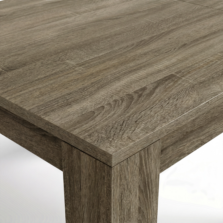 [Wooden Grey] Close-up of the grey wood-effect tabletop corner and thick L-shaped leg; mixed grain runs across both surfaces.
