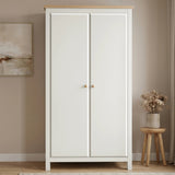 [White] wardrobe with wooden top in a room with a stool and plant