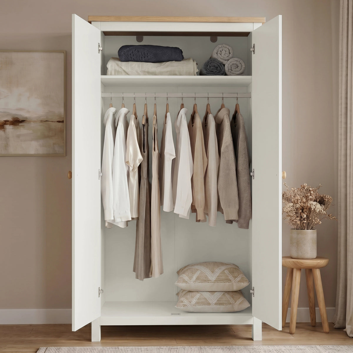 [White] Open wardrobe with clothes and pillows in a room with a wooden stool and plant