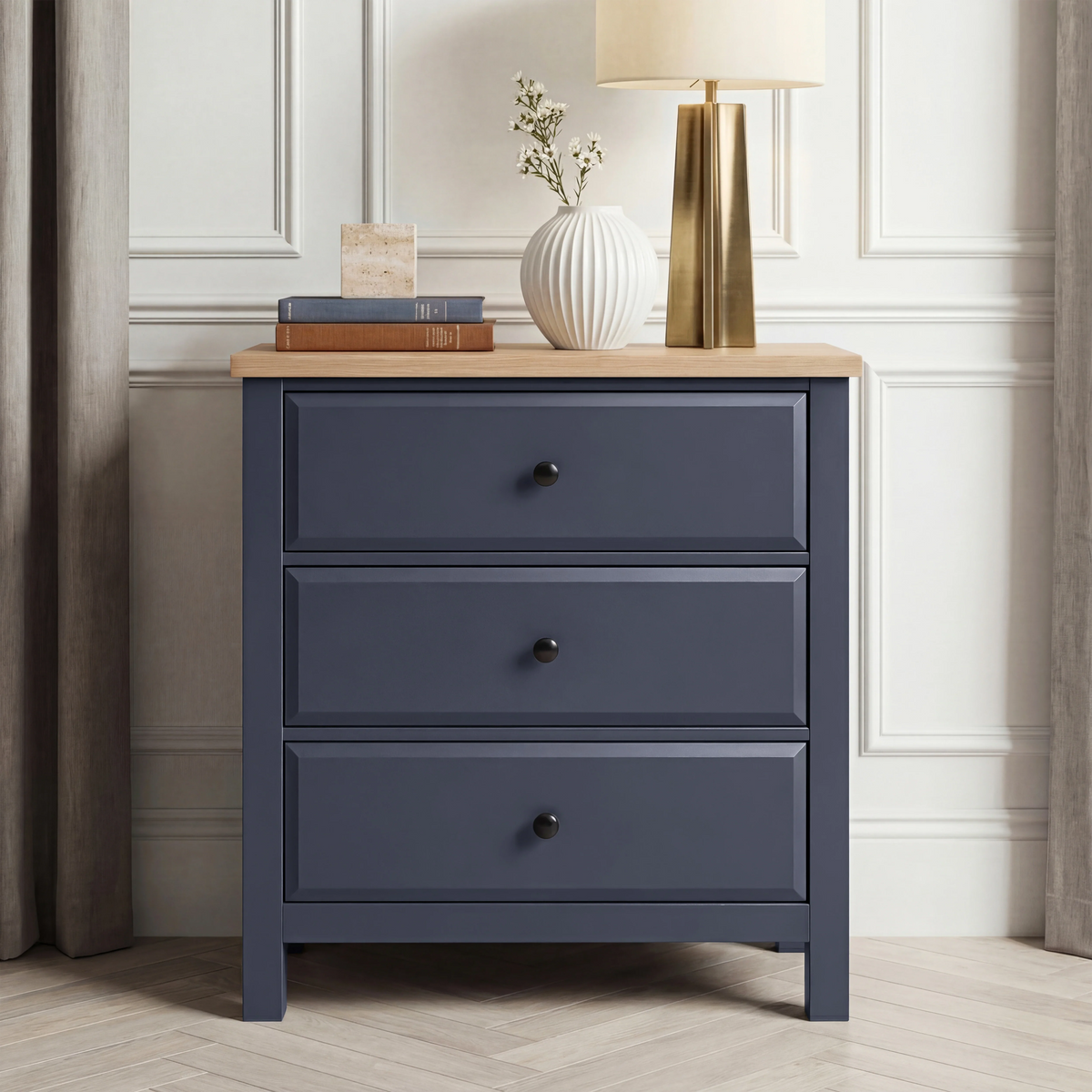[Blue] Haven 3-drawer chest front view in a neutral styled room with decorative objects on oak veneer top