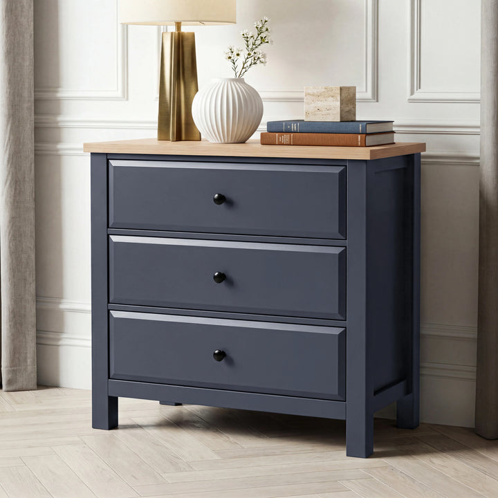 [Blue] Haven 3-drawer chest front three-quarter view with brass lamp, white vase and stacked books on oak veneer top