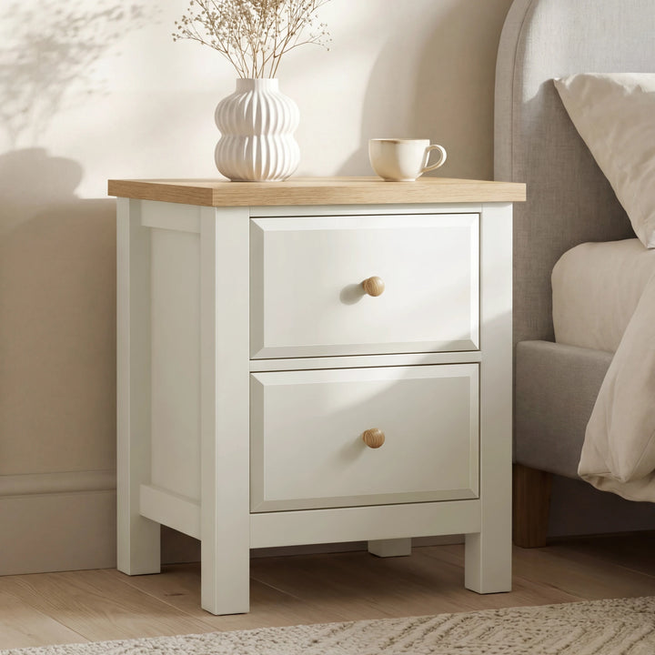 [White] 2 drawers nightstand with wooden top next to a bed in a bedroom setting