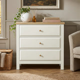[White] Haven 3-drawer chest front view in a room with armchair, wicker basket and decorative items on oak top