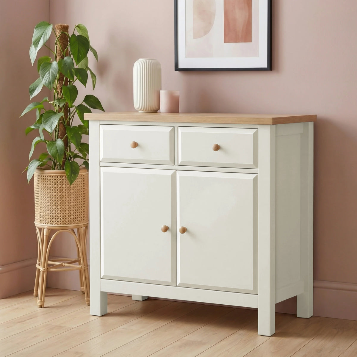 [White] sideboard with oak veneer top in a room with a plant and framed picture.