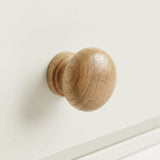 [White] Haven 5-drawer tall chest close-up of a round solid oak wooden knob handle on a painted drawer front