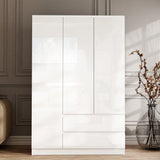 [White] 3 door wardrobe in white gloss with two storage drawers below, dried branches in floor vase beside