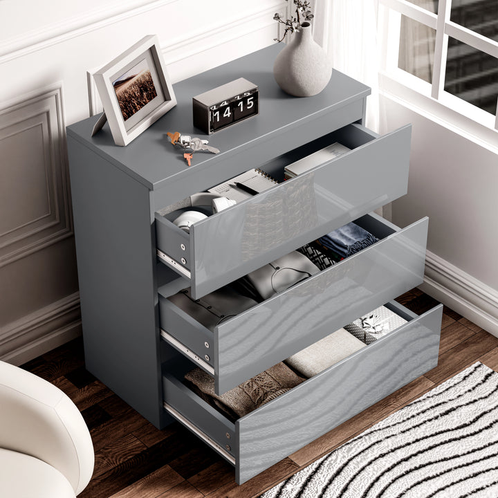 [Grey] high gloss chest with every drawer extended revealing folded garments and metal runners