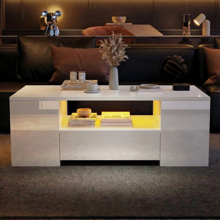 [White] Angled view of white gloss LED coffee table in front of dark leather sofa, yellow lighting on