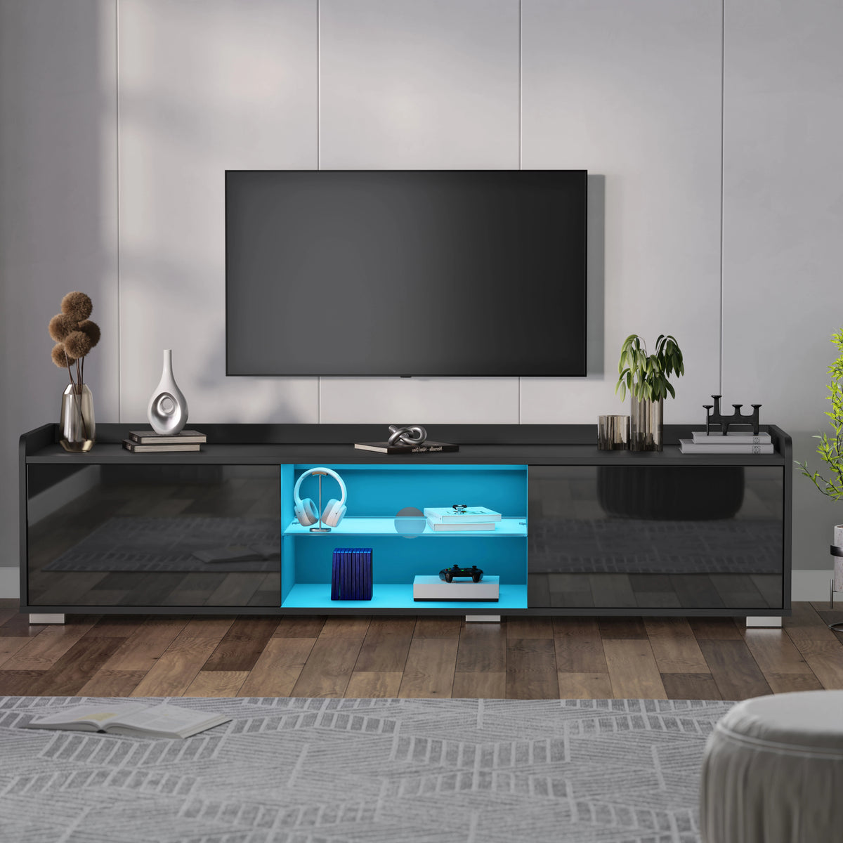 [Black] black gloss LED TV cabinet against white wall with vase, books and tall plant beside