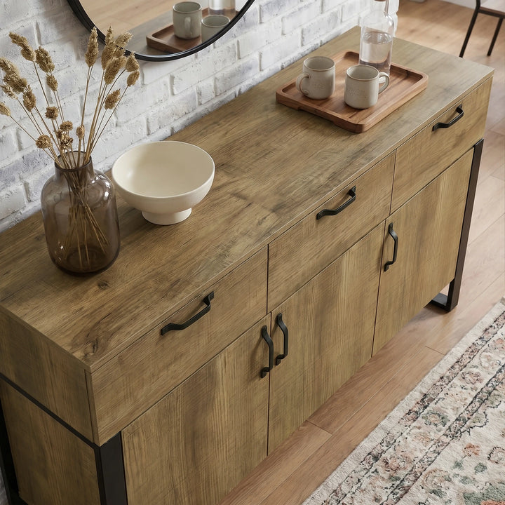[Oak Effect] Ironmere sideboard oblique room view with serving pieces on top and three drawers below