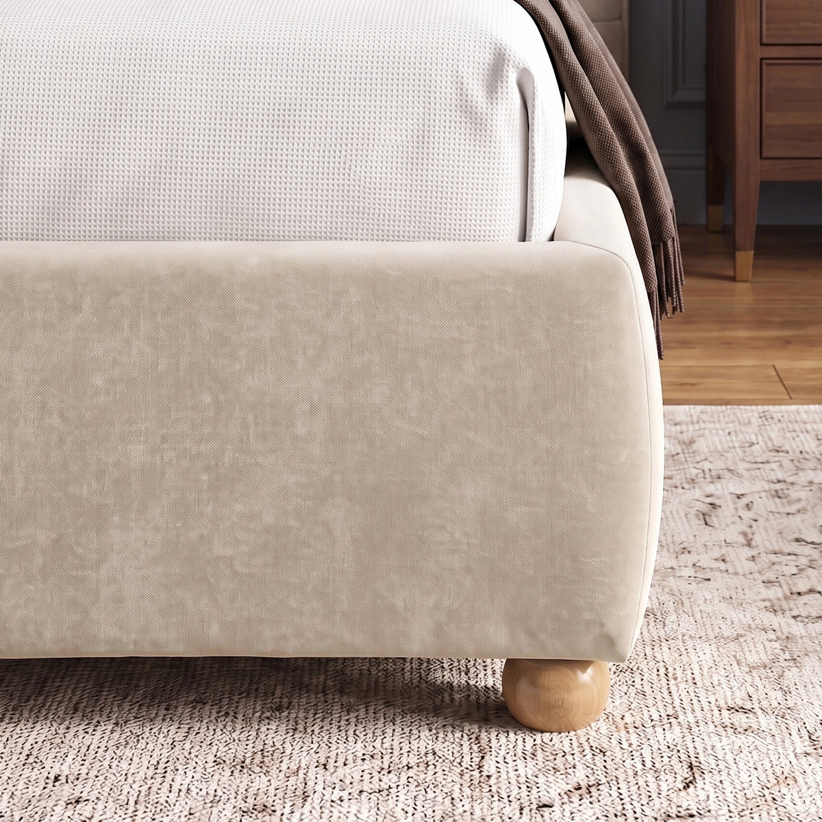 [King | Beige] Corner side detail of beige king bed frame emphasizing soft fabric texture of footboard and wooden legs