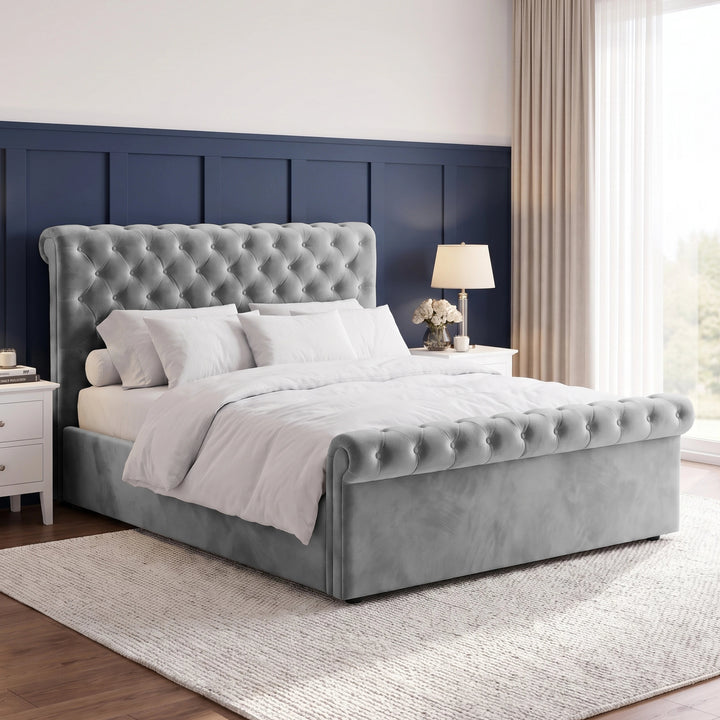 [King | Grey] Angled bedroom view with tufted headboard, rolled footboard, white bedding, bedside tables, and tall window