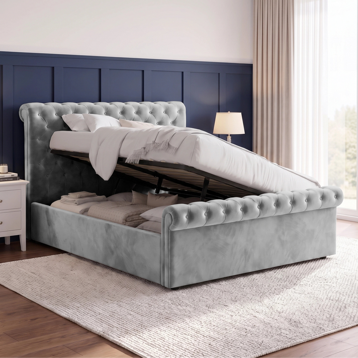 [King | Grey] Side-lift storage view with raised mattress base, black frame, folded bedding, pillows, and window curtains