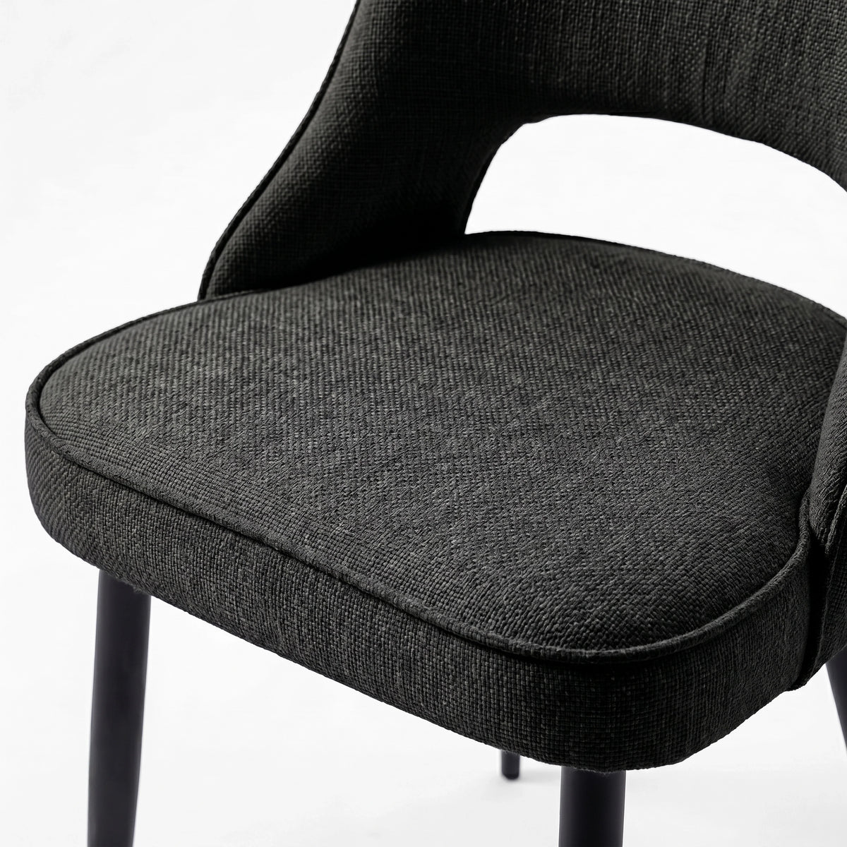 [Black | Tinted] Close-up of the 4 seater Kyvon black upholstered fabric comfy chair seat with black metal legs