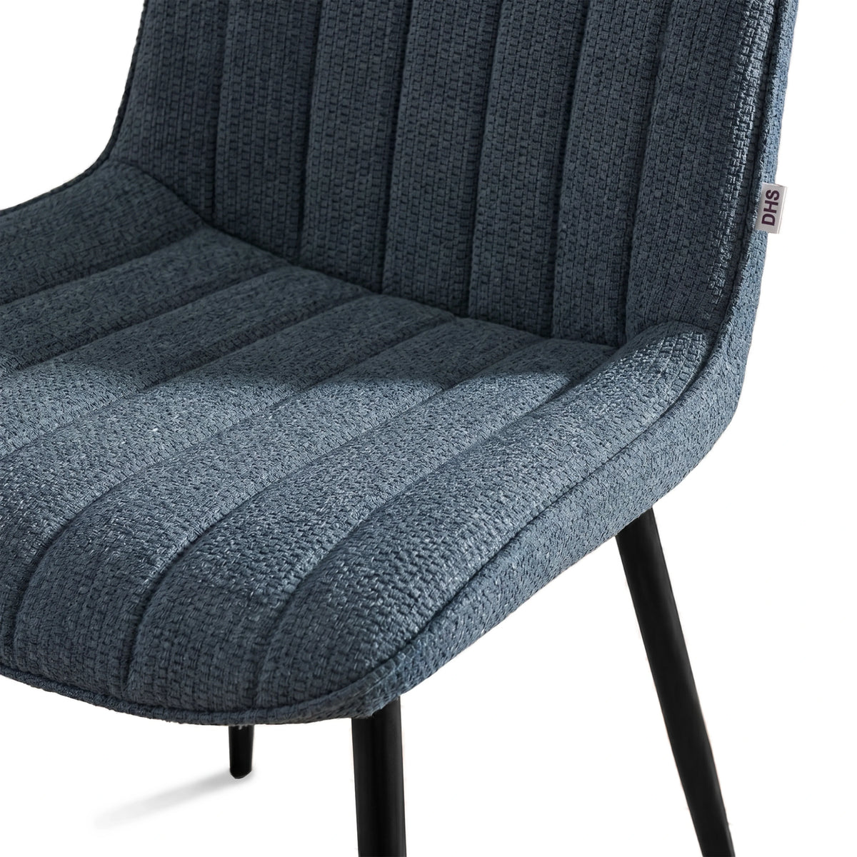 [Vertical Blue | Clear] Close-up of Kyvon blue upholstered fabric channeled stitched chair seat with black metal legs