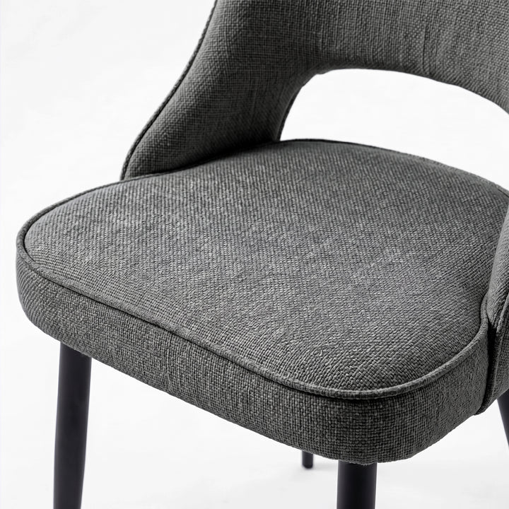 [Grey | Tinted] Close-up of the 4 seater Kyvon grey upholstered fabric comfy chair seat with black metal legs