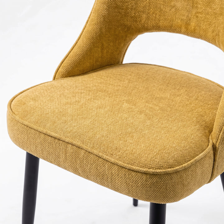 [Mustard | Tinted] Close-up of the 4 seater Kyvon mustard upholstered fabric comfy chair seat with black metal legs
